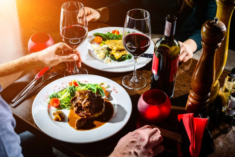 Personen essen Steak, mit Wein, Sauce und Beilagen in Recklinghausen